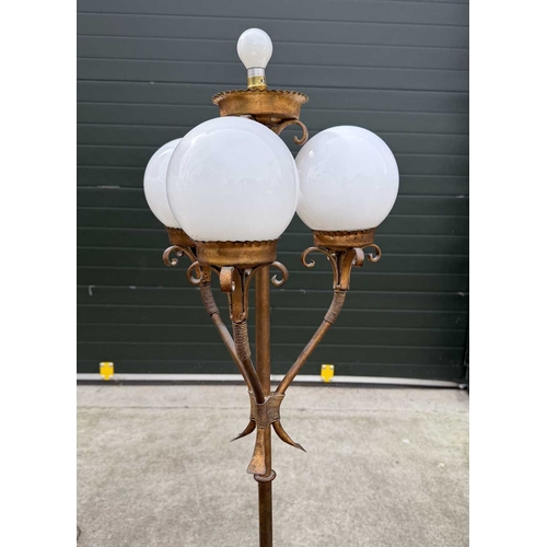 567 - A gilded wrought metal 4-light standard lamp, central column with light supported by scrolls above t... 