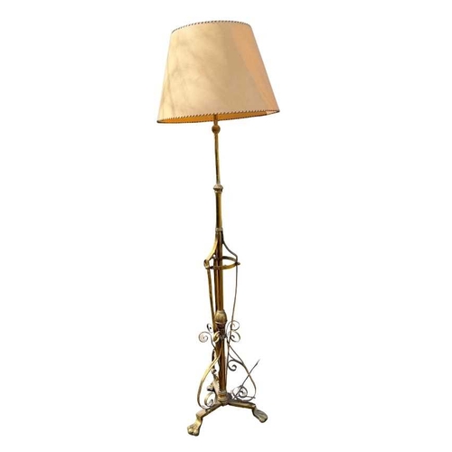 568 - A brass art nouveau-style standard lamp, telescopic, Scrolling strapwork to tri-from base with paw f... 