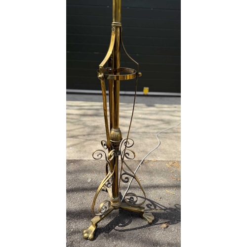 568 - A brass art nouveau-style standard lamp, telescopic, Scrolling strapwork to tri-from base with paw f... 