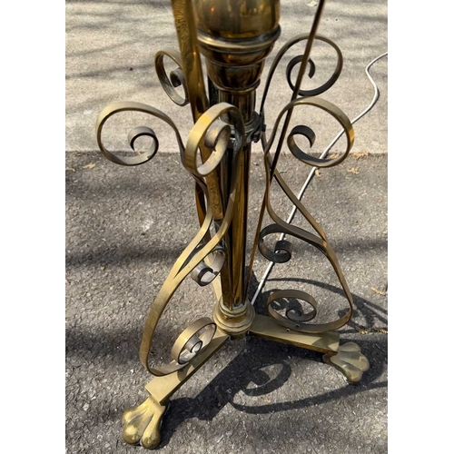568 - A brass art nouveau-style standard lamp, telescopic, Scrolling strapwork to tri-from base with paw f... 