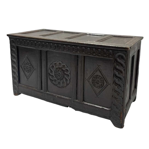 579 - An 18th century or earlier oak coffer, four panel top opening to storage, three carved panel front, ... 