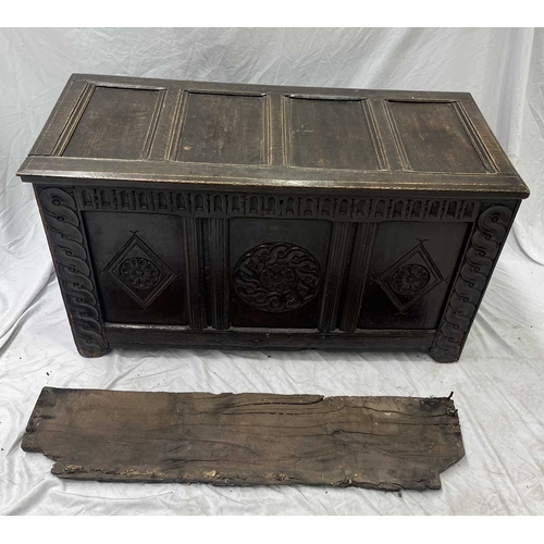 579 - An 18th century or earlier oak coffer, four panel top opening to storage, three carved panel front, ... 