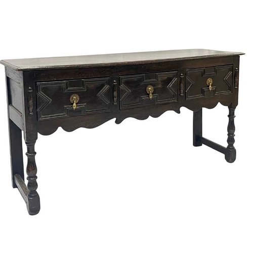 580 - A Jacobean oak dresser base or sideboard, two plank top above three deep drawers each with a central... 