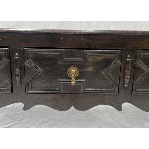 580 - A Jacobean oak dresser base or sideboard, two plank top above three deep drawers each with a central... 