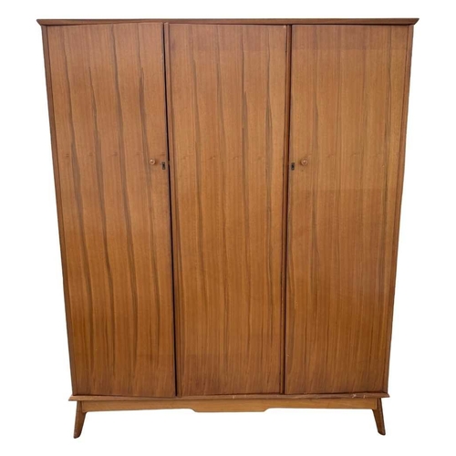 588 - Alfred Cox for AC furniture, a mid-century teak triple wardrobe, c.1950, the end doors with tapered ... 