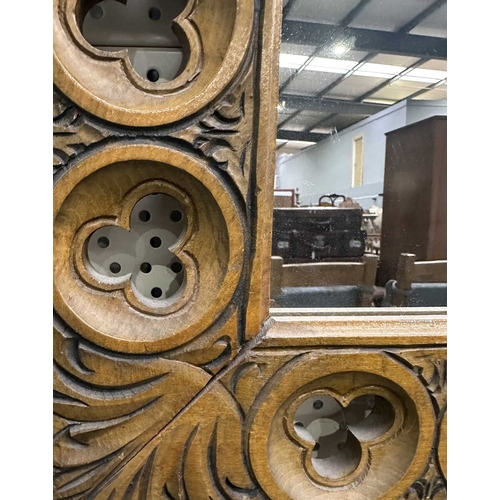 594 - A carved beech-framed wall mirror, the frame with cut-out trefoil shapes in roundels, height 88.5cm,... 