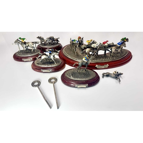 84 - A small group of hand painted, cast metal figurines of jockeys racing horses, mounted to wooden plin... 