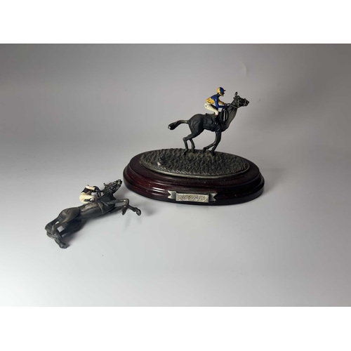 84 - A small group of hand painted, cast metal figurines of jockeys racing horses, mounted to wooden plin... 