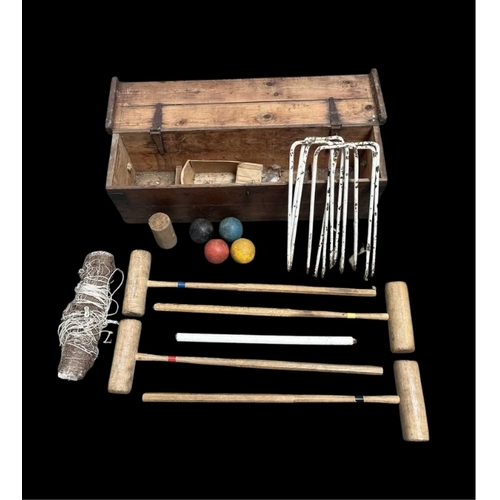 590 - An early 20th century croquet set, containing mallets, balls, hoops, a net etc, boxed, height 26cm, ... 
