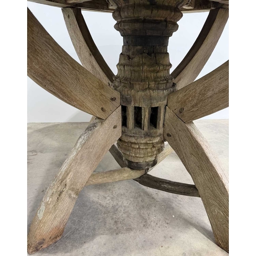 672 - An oak garden table assembled with wooden wheel components, consisting of a circular wooden wheel to... 