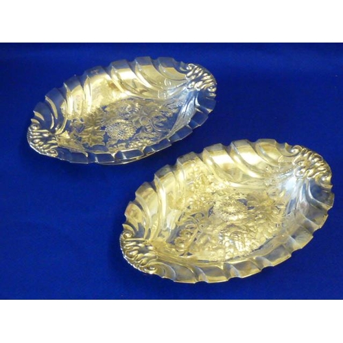 226 - A pair of hallmarked silver boat-shaped Bowls, each finely decorated to the centre repoussé style wi... 