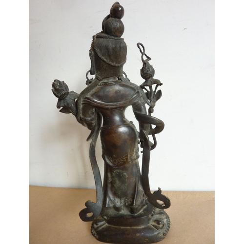 119 - A patinated bronze model of a female deity in the Sino-Tibetan style; the figure standing upon a lot... 