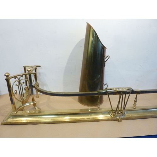 135 - An elaborate early-20th century brass fire fender with raised sides together with a tapering cylindr... 