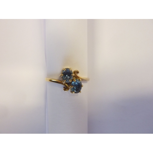 185 - A 9-carat gold, blue stone, crossover ring