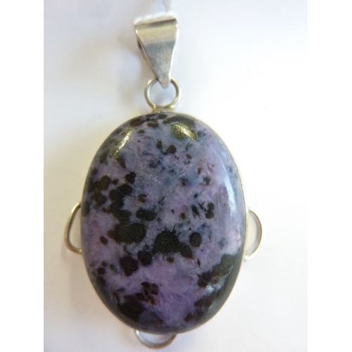 195 - An oval silver mounted pendant set with a mauve cabouchon hardstone