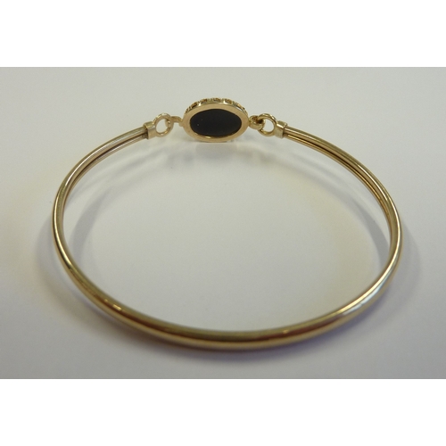 199 - A 9-carat gold bangle set with a large cabouchon stone