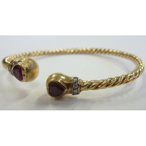 205 - An 18-carat gold heavy ball-end bangle set with rubies and diamonds