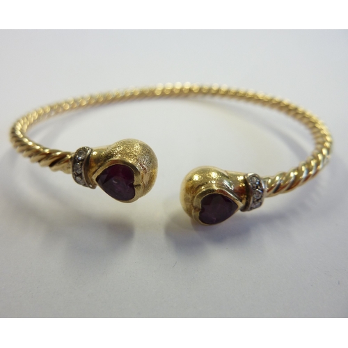 205 - An 18-carat gold heavy ball-end bangle set with rubies and diamonds