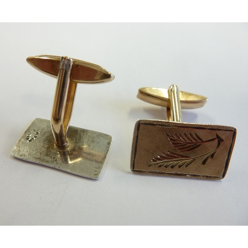 209 - A pair of gentlemen's gold on silver cufflinks hand engraved with ferns etc.,