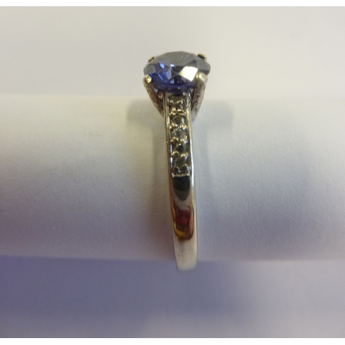 213 - A 9-carat white gold and sapphire ring with diamond shoulders