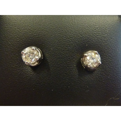 239 - A pair of 18-carat white gold and solitaire diamond ear studs