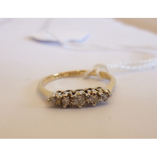 247 - An 18-carat yellow gold ring set with a horizontal band of five small diamonds mounted into white me... 