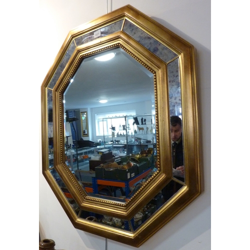 427 - A wall hanging octagonal mirror in Venetian style with gilt frame and hand bevelled plate, frame siz... 