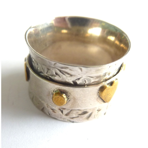 101C - ADDED LOT        An unusual handmade waisted silver ring, the central revolving band decorated with ... 