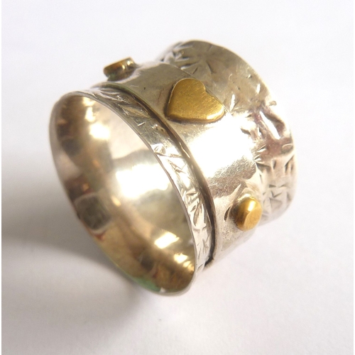 101C - ADDED LOT        An unusual handmade waisted silver ring, the central revolving band decorated with ... 