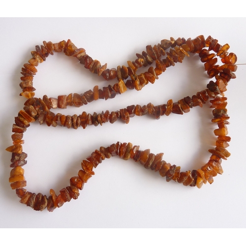 107A - ADDED LOT      A long string of unpolished natural amber pieces, approx. 92cm