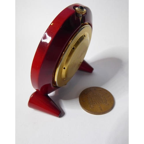 222 - A Verdura miniature travel clock; red-and-brown faux-marble case surrounding a gold insert and white... 