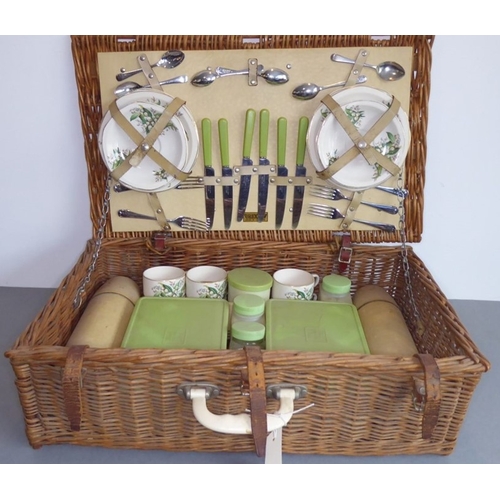 228 - A mid-20th century wickerwork picnic basket by Brexton comprising plates, side plates, cups, saucers... 