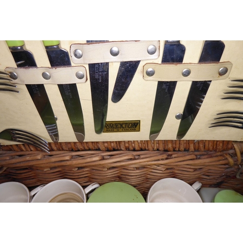 228 - A mid-20th century wickerwork picnic basket by Brexton comprising plates, side plates, cups, saucers... 