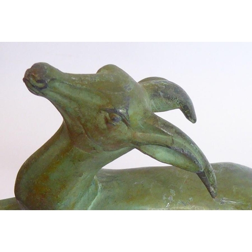 106 - A pair of Art Deco book ends modelled as naturalistic verdigris leaping gazelles, each on black and ... 