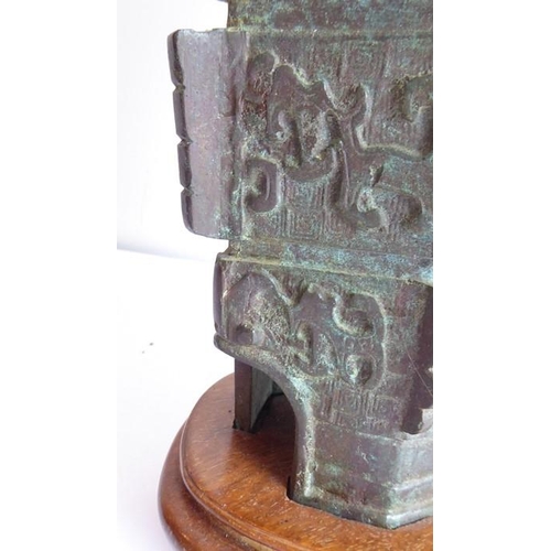 108 - An archaistic-style heavily patinated Chinese bronze wood-mounted table lamp; the height-adjustable ... 