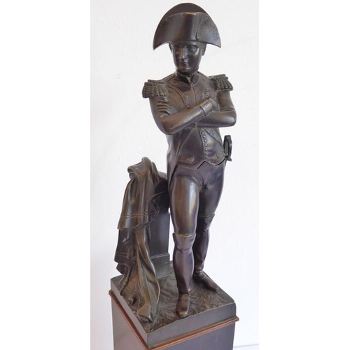 125 - A late 19th/early 20th century patinated bronze sculpture of Napoleon; with arms crossed, his sword ... 