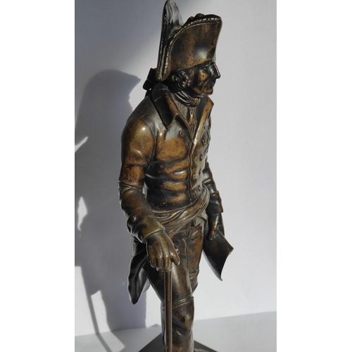 126 - A 19th century patinated bronze of a soldier in bicorn hat; in his left hand he holds a scroll and i... 