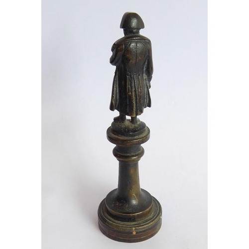 127 - A small 19th century patinated bronze model of Napoleon upon a circular socle (12.5cm high)