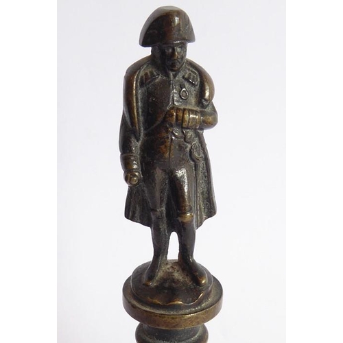 127 - A small 19th century patinated bronze model of Napoleon upon a circular socle (12.5cm high)