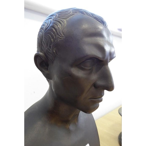 134 - A 19th century patinated bronze bust of Julius Caesar on a variegated rouge marble circular socle ba... 