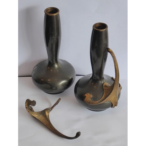 140 - A pair of late 19th/early 20th century patinated bronze bottle vases; the gilded handles in high Art... 