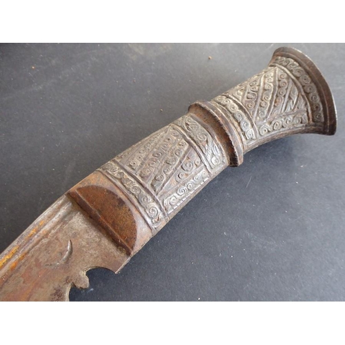 146 - A Ghurka-style Kukri in scabbard; the metal handle decorated with circular scrolls within vertical a... 