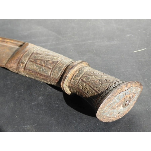 146 - A Ghurka-style Kukri in scabbard; the metal handle decorated with circular scrolls within vertical a... 