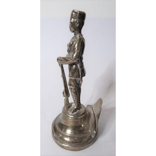 181 - A silver menu holder in the form of an askari of the King’s African Rifles; the Goldsmiths & Silvers... 