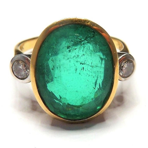 253 - An 18-carat ladies ring set with a large emerald (15mm x 12mm, approx. 6 carat) flanked by two diamo... 