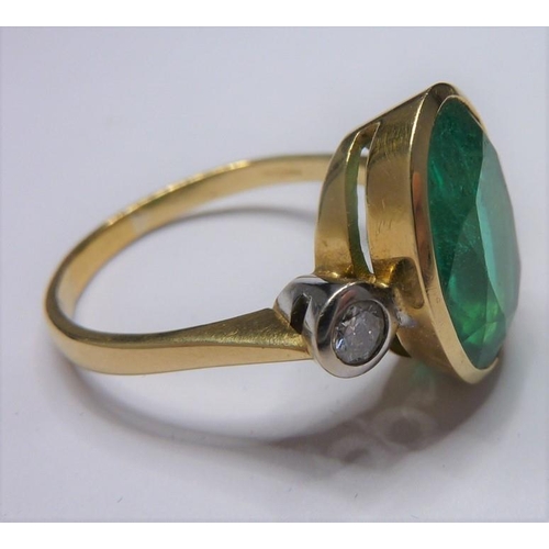 253 - An 18-carat ladies ring set with a large emerald (15mm x 12mm, approx. 6 carat) flanked by two diamo... 