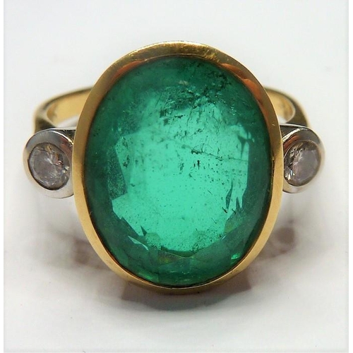 253 - An 18-carat ladies ring set with a large emerald (15mm x 12mm, approx. 6 carat) flanked by two diamo... 