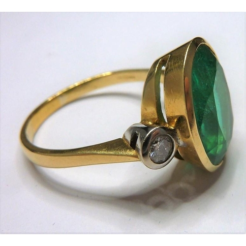 253 - An 18-carat ladies ring set with a large emerald (15mm x 12mm, approx. 6 carat) flanked by two diamo... 