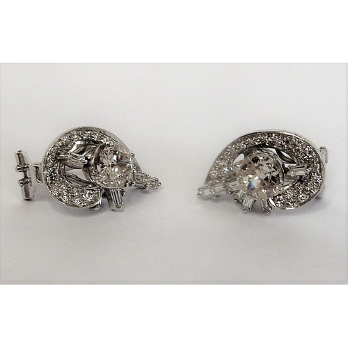 258 - A pair of diamond cluster earrings, the centre stones 1 carat each surrounded by baguette and brilli... 