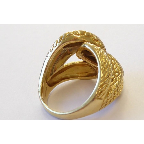 313 - An early 1970s 18 carat yellow gold and diamond-set dress ring, the textured double knot design set ... 